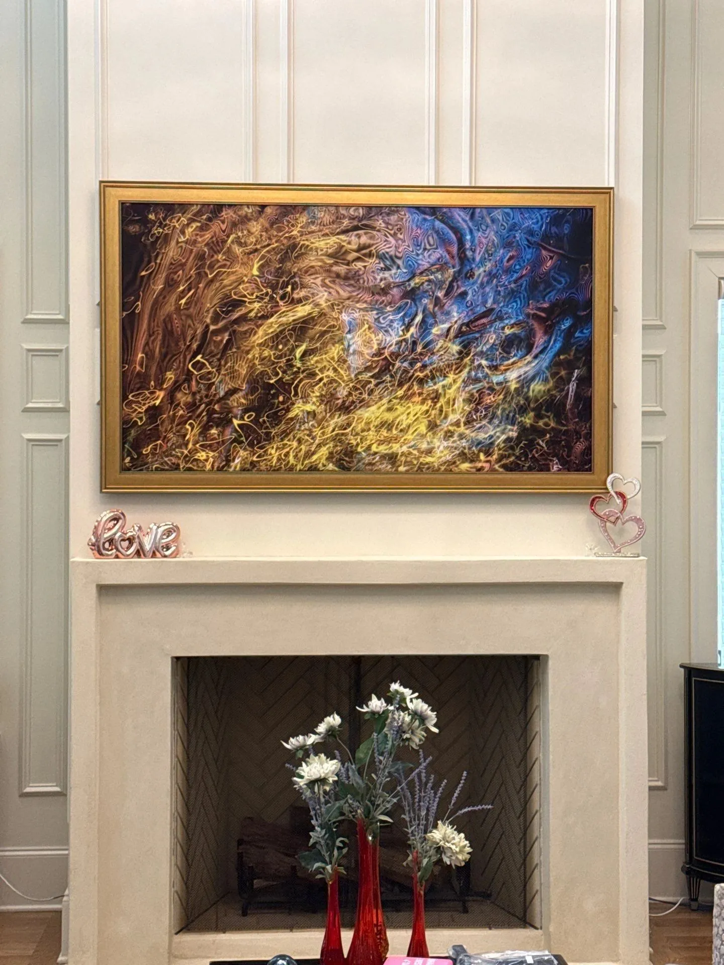 Samsung Frame TV in art mode over a white fireplace surround